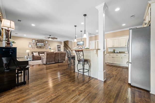 kitchen with visible vents, freestanding refrigerator, ornamental molding, open floor plan, and a ceiling fan
