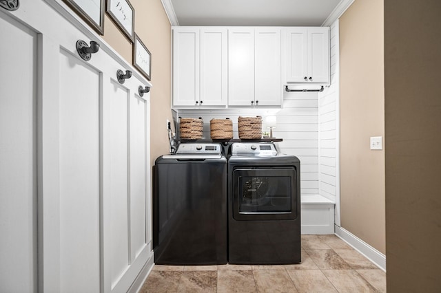 clothes washing area featuring separate washer and dryer, baseboards, and cabinet space