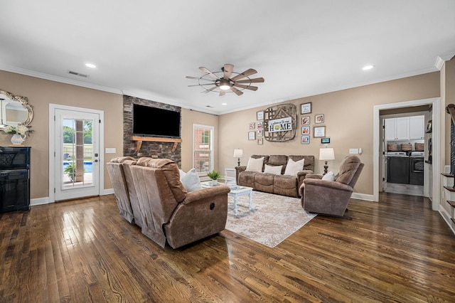 living area featuring a ceiling fan, visible vents, a wealth of natural light, and dark wood finished floors