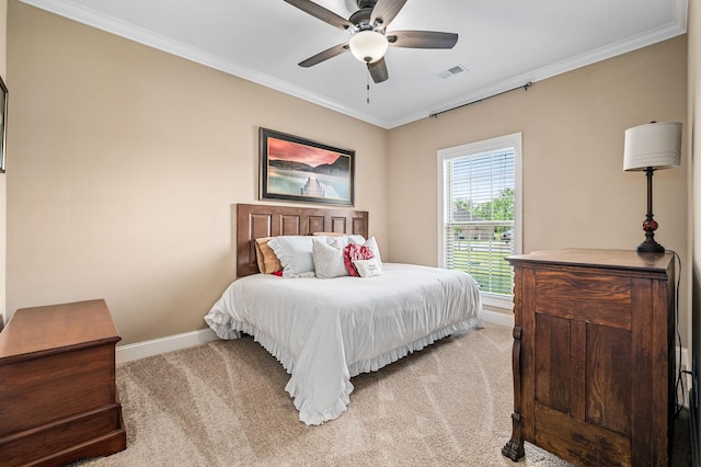 bedroom featuring ceiling fan, visible vents, baseboards, ornamental molding, and light carpet