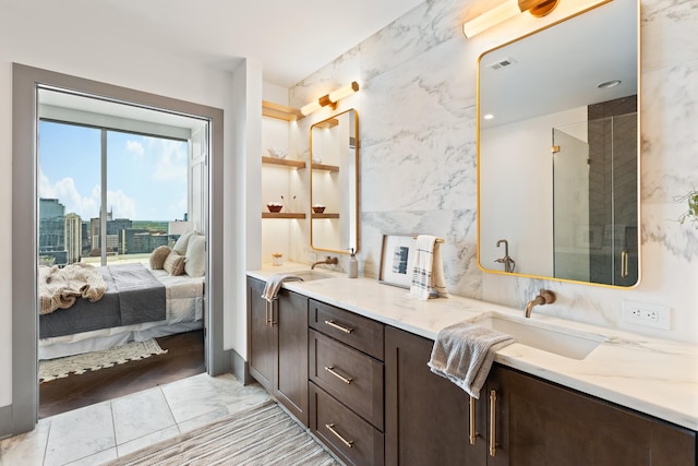 full bathroom featuring a sink, ensuite bath, double vanity, and visible vents