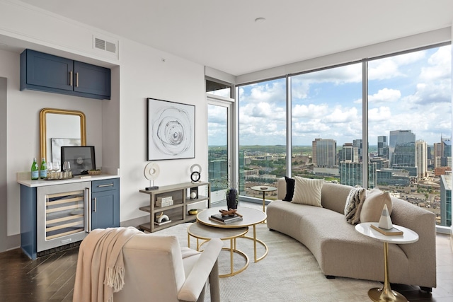 living room featuring visible vents, wine cooler, wood finished floors, floor to ceiling windows, and a city view
