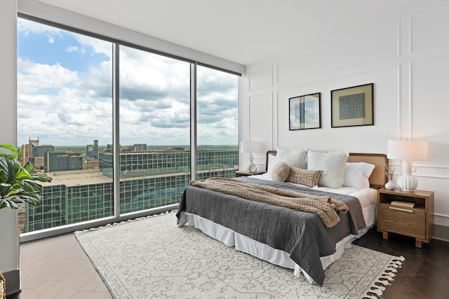 bedroom featuring expansive windows and a decorative wall