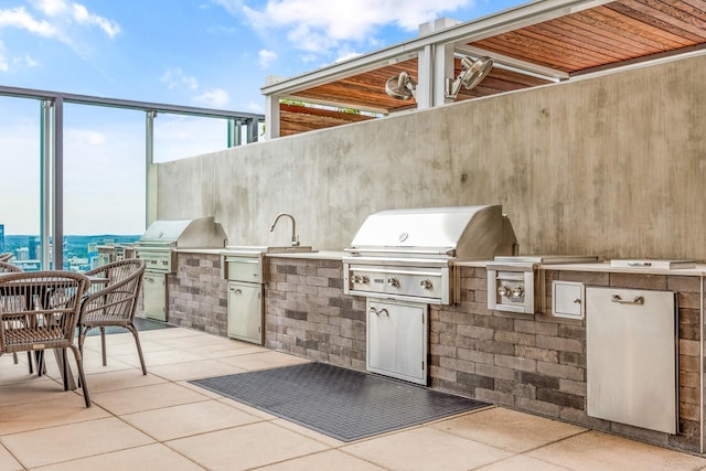 view of patio / terrace with a sink, grilling area, and an outdoor kitchen