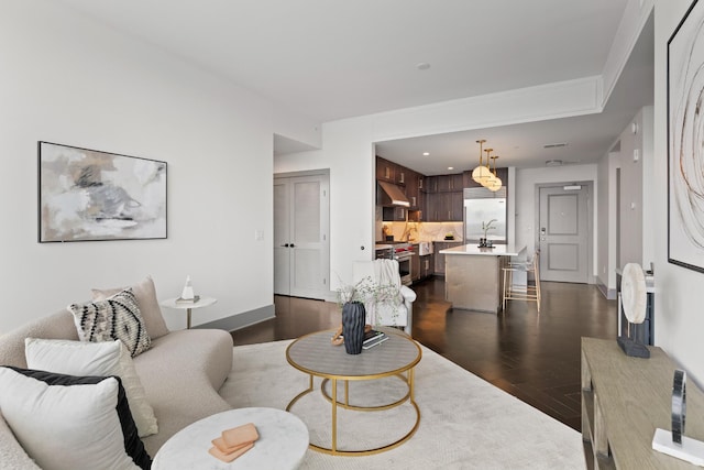 living room with baseboards and dark wood-style floors