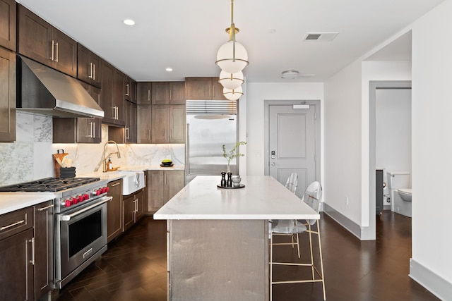 kitchen with a center island, recessed lighting, under cabinet range hood, a sink, and premium appliances