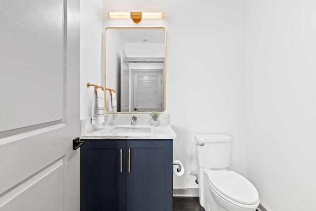 bathroom with toilet, baseboards, tile patterned flooring, and vanity