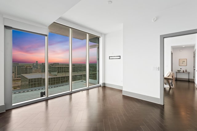 unfurnished room with baseboards and floor to ceiling windows