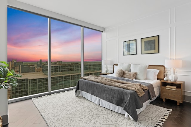 bedroom featuring a wall of windows, multiple windows, and a decorative wall