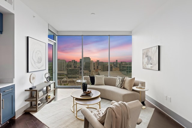 living room featuring a view of city, dark wood-style flooring, baseboards, and a wealth of natural light