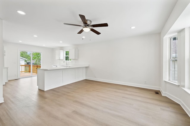 unfurnished living room with ceiling fan, visible vents, baseboards, light wood-type flooring, and recessed lighting