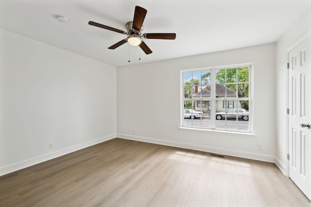 unfurnished bedroom with wood finished floors, visible vents, a ceiling fan, and baseboards