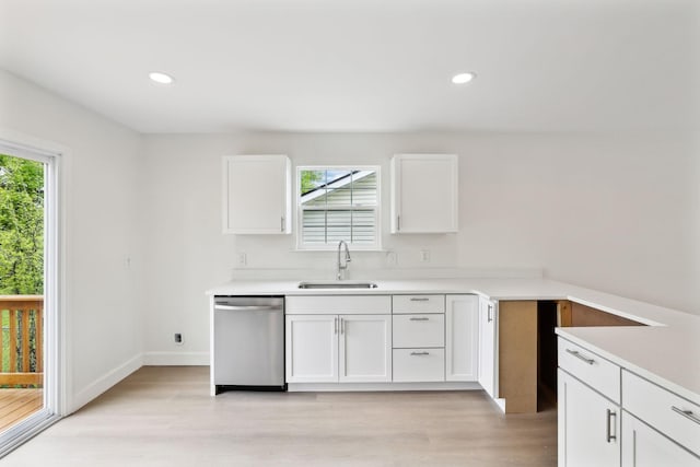 kitchen featuring stainless steel dishwasher, a sink, light wood-style floors, and plenty of natural light