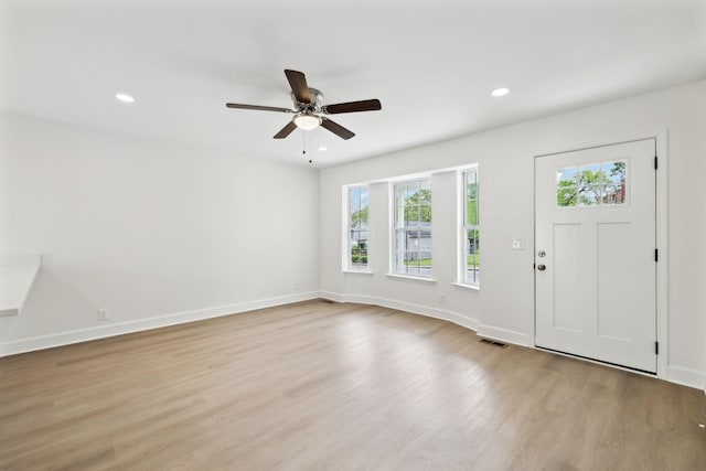 foyer entrance with visible vents, wood finished floors, a wealth of natural light, and ceiling fan