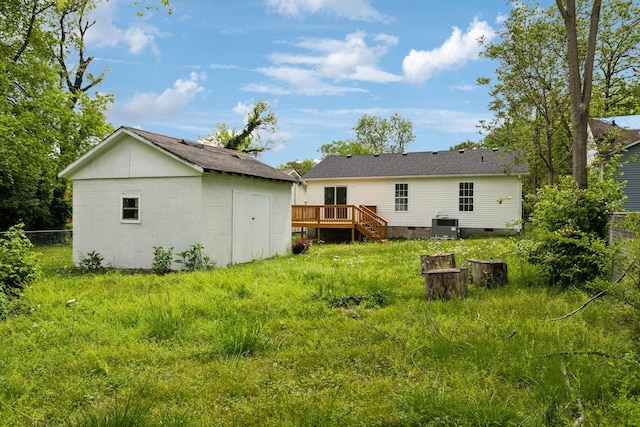 back of house featuring a wooden deck, an outbuilding, a storage shed, fence, and central AC unit