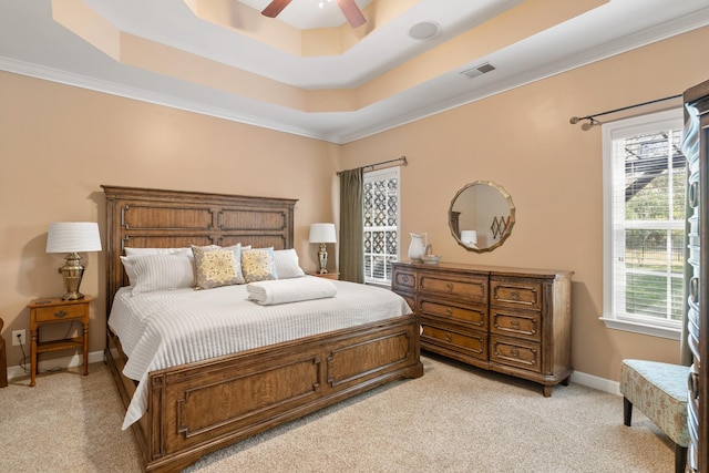 bedroom featuring light colored carpet, a raised ceiling, crown molding, a ceiling fan, and baseboards