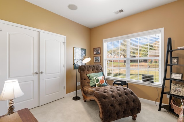 living area with light colored carpet and baseboards