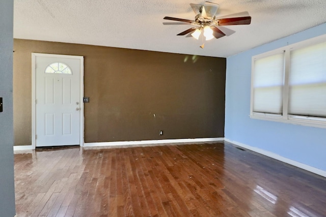 entrance foyer featuring a ceiling fan, hardwood / wood-style floors, a textured ceiling, and baseboards
