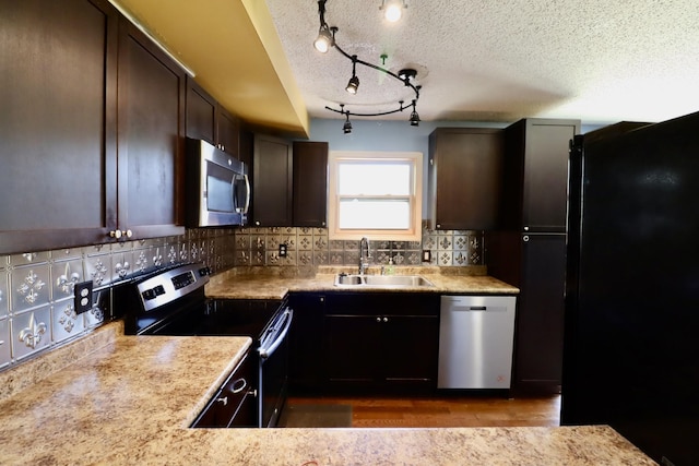 kitchen with backsplash, appliances with stainless steel finishes, light countertops, and a sink