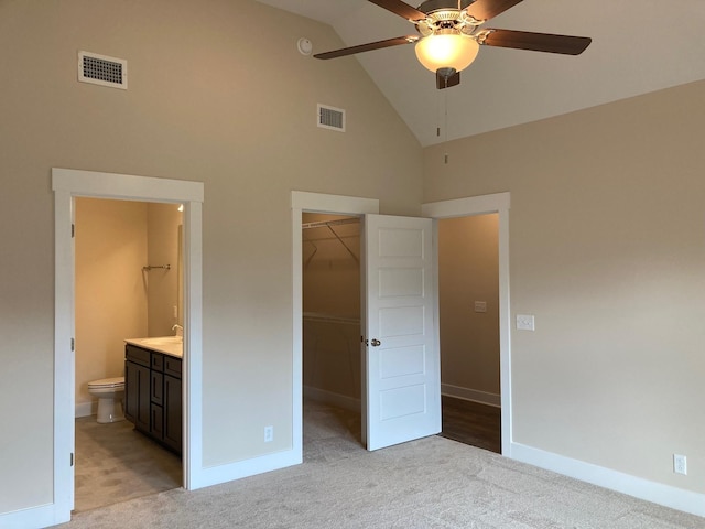 unfurnished bedroom with visible vents, light carpet, high vaulted ceiling, and a spacious closet