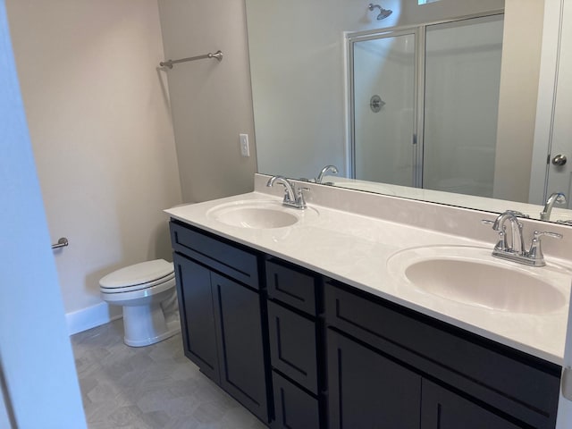 full bathroom featuring a stall shower, toilet, double vanity, and a sink