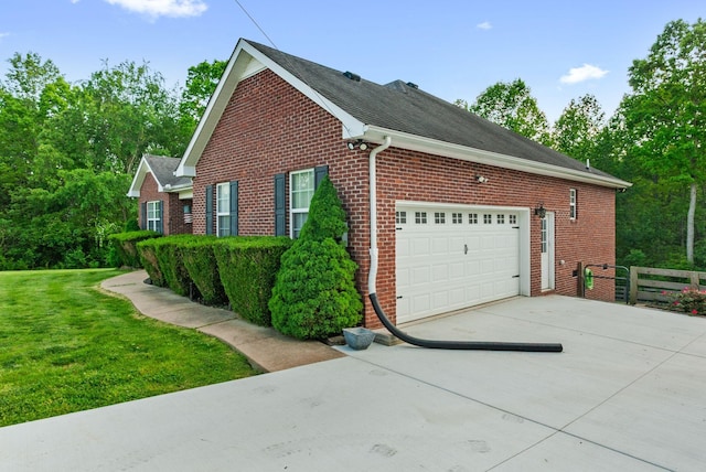 204 Commanche Dr, Hohenwald, TN 38462 - view of home's exterior with a garage, fence, brick siding, concrete driveway, and a yard