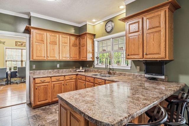 kitchen featuring ornamental molding, a wealth of natural light, a peninsula, and a sink