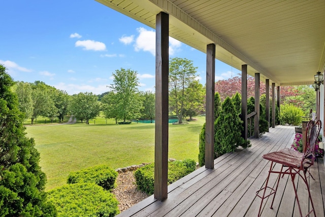 wooden deck featuring a lawn and a porch