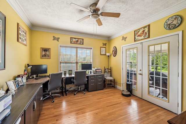 office area with light wood finished floors, a textured ceiling, and a healthy amount of sunlight