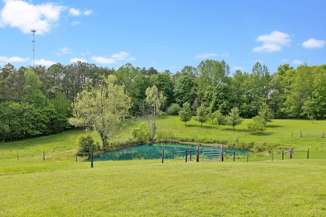 view of property's community featuring a lawn and fence