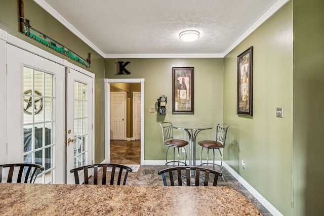 dining area with baseboards, a textured ceiling, and crown molding