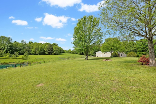 view of yard with fence and a rural view