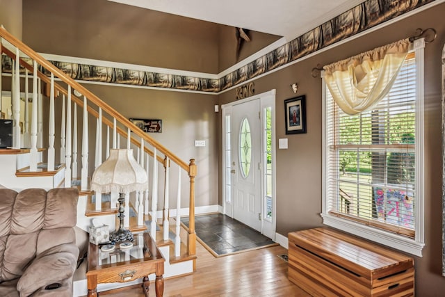 entrance foyer featuring wood-type flooring, stairs, and baseboards