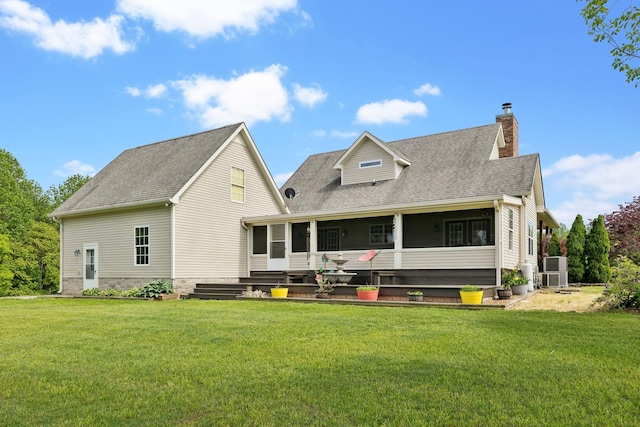 back of property featuring a chimney, a yard, a shingled roof, and a sunroom