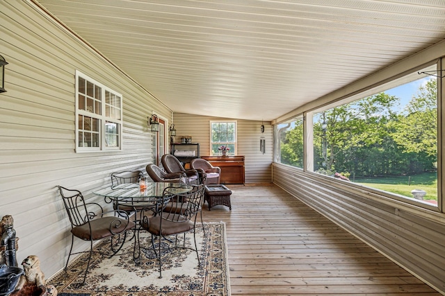 sunroom with wooden walls and wood-type flooring