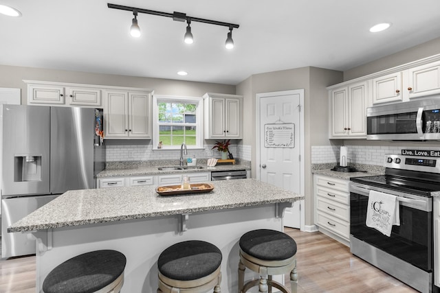 1356 Sayles Cir, Lawrenceburg, TN 38464 - kitchen with a breakfast bar, a sink, stainless steel appliances, and light wood-style floors