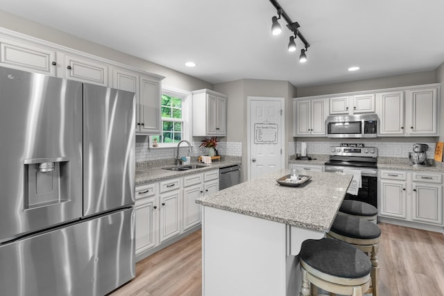 1356 Sayles Cir, Lawrenceburg, TN 38464 - kitchen with tasteful backsplash, stainless steel appliances, a kitchen island, light wood finished floors, and a sink