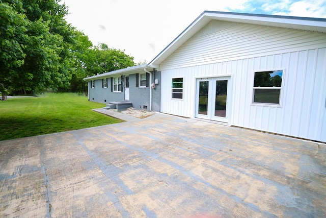 rear view of property with a patio and a lawn