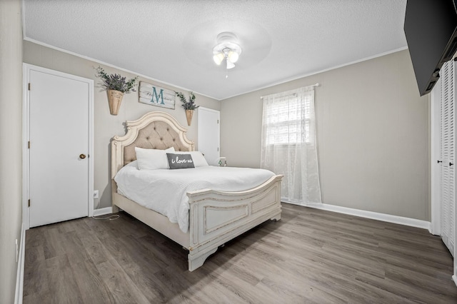 bedroom with ornamental molding, a textured ceiling, and wood finished floors