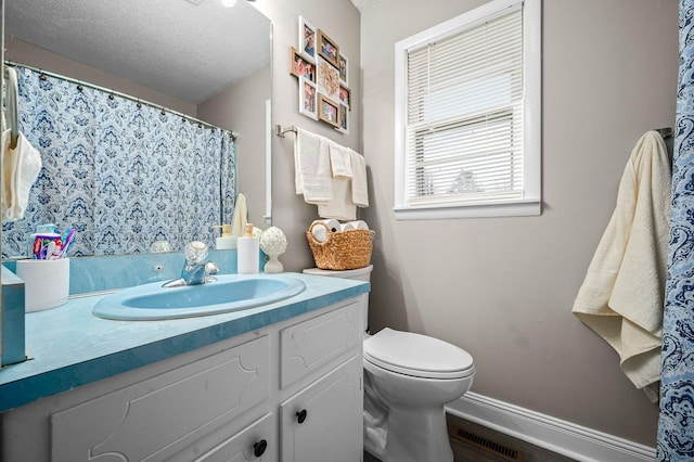 full bathroom with vanity, toilet, visible vents, baseboards, and a textured ceiling