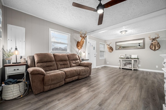 living area with a textured ceiling, ceiling fan, and wood finished floors