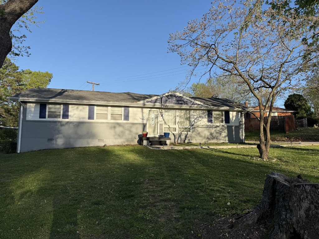 back of house featuring a yard and crawl space