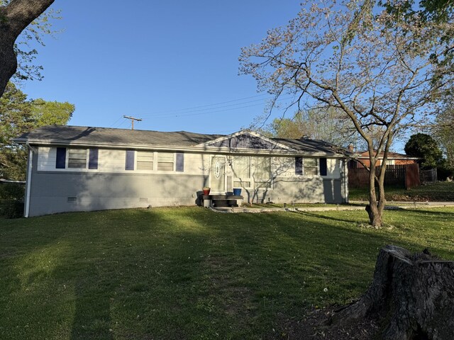 back of house featuring a yard and crawl space