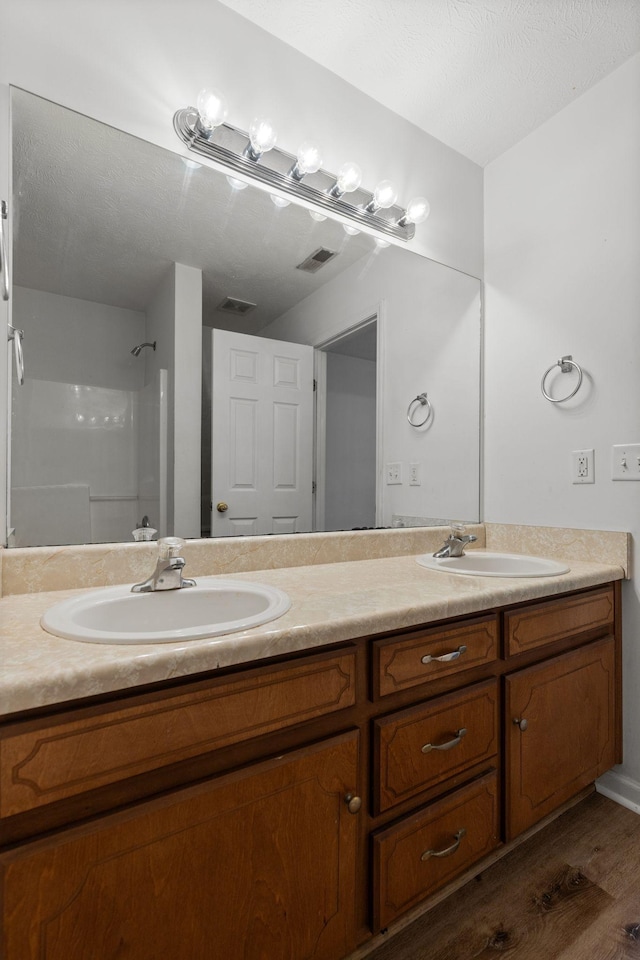 bathroom with double vanity, visible vents, and a sink
