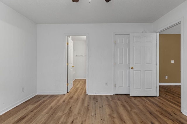 unfurnished bedroom with wood finished floors, ceiling fan, and baseboards