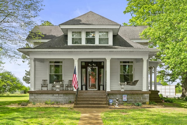 view of front of home with a porch, a shingled roof, and a front yard