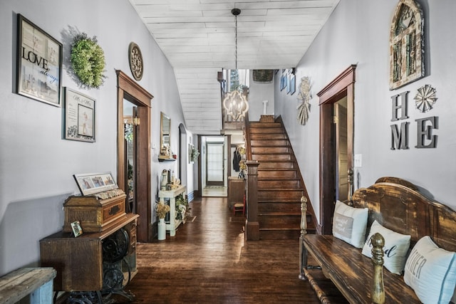 corridor with an inviting chandelier, stairway, and wood finished floors