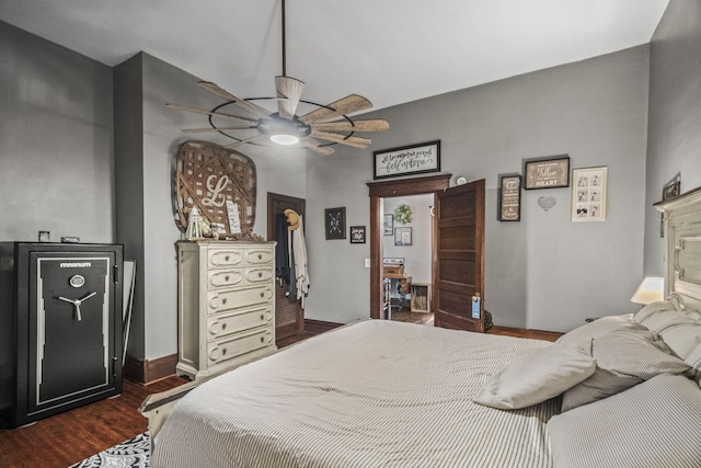 bedroom featuring dark wood-type flooring, a ceiling fan, and baseboards