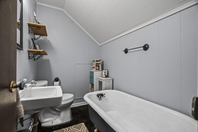 bathroom featuring a freestanding tub, toilet, crown molding, vaulted ceiling, and a decorative wall