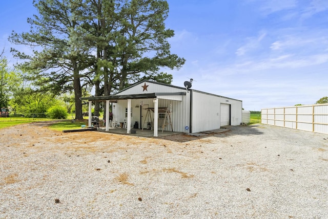view of outbuilding featuring fence and an outbuilding